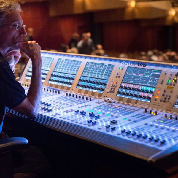 Man Sitting in Front of Audio Mixer